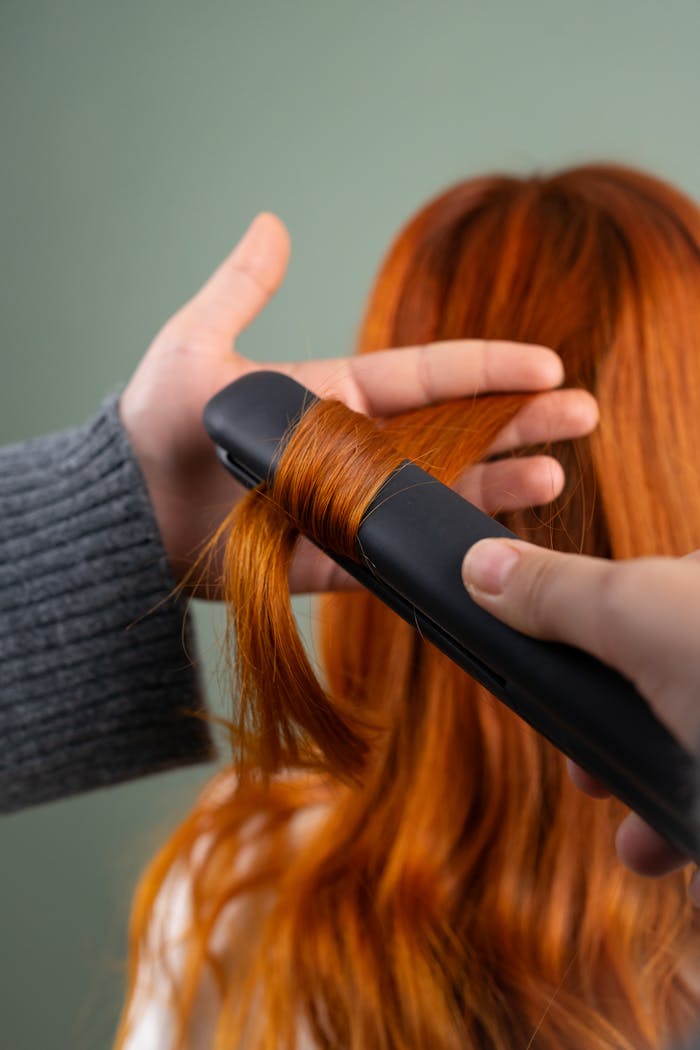 Crafting Captivating Headlines: Your awesome post title goes here Close-up of red hair being styled with a flat iron indoors.