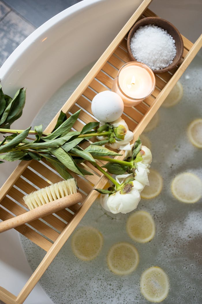 The Art of Drawing Readers In: Your attractive post title goes here Top view of wooden tray with bath bomb and burning candle placed near salt and flowers on tub with lemon slices on water
