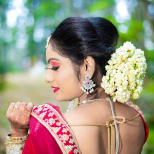 Beautiful woman wearing traditional Indian sari with flowers outdoors, showcasing cultural elegance.